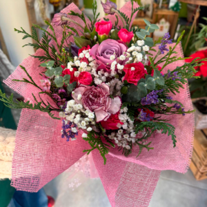 Ramo de flores variadas en tonos rosas, rojos y morados